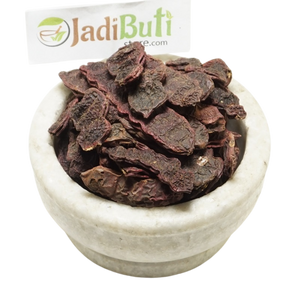 Dried Shikakai pods and pod pieces in a bowl with a Jadibuti Store card