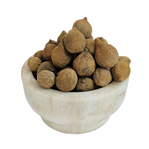 Baheda rounded brown dried whole fruits in a stone bowl — Jadibuti Store