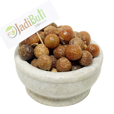 Dried Reetha soapnut fruits in a bowl with a Jadibuti Store card
