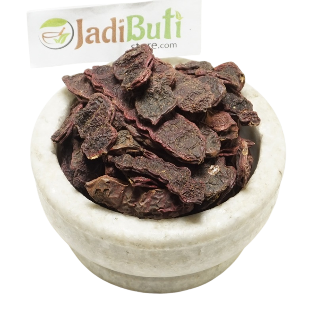 Dried Shikakai pods and pod pieces in a bowl with a Jadibuti Store card
